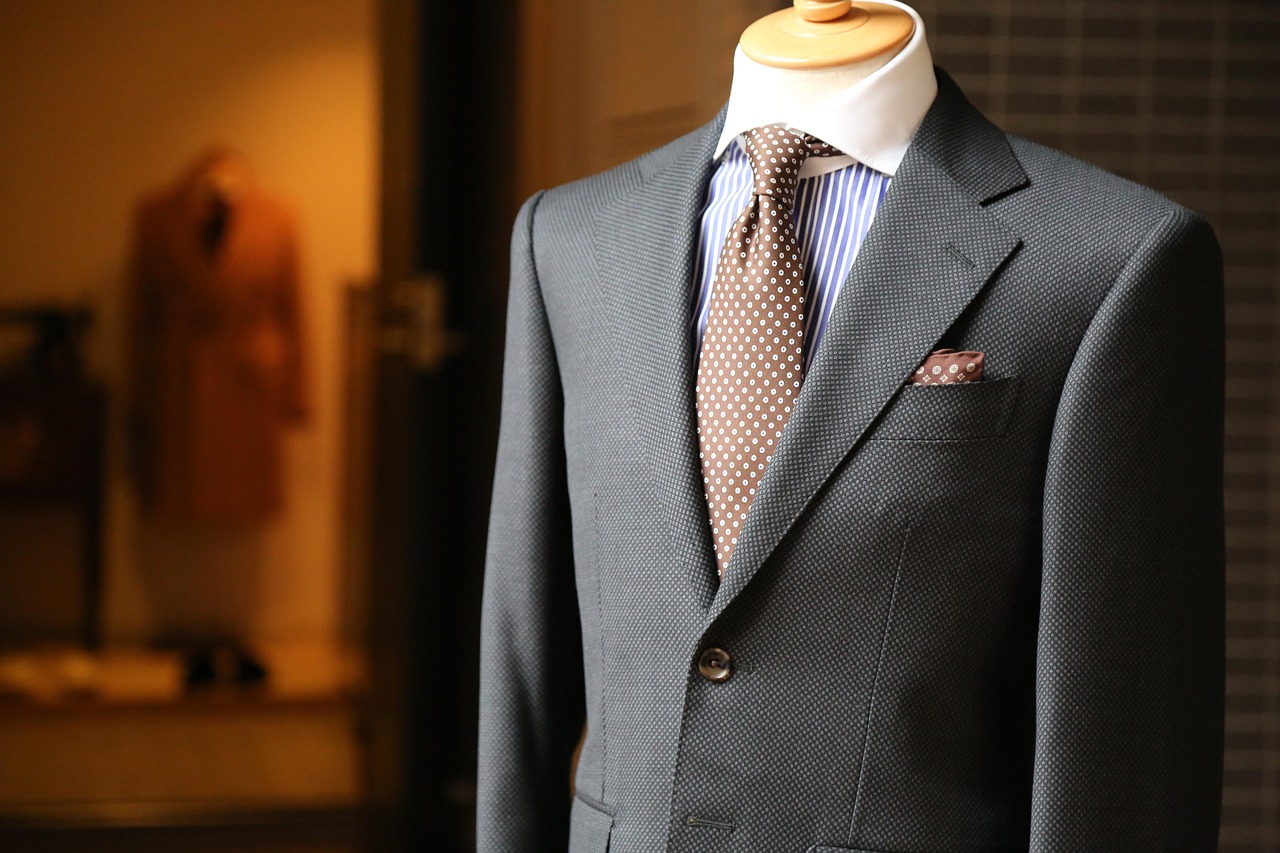 Master tailor measuring client for custom suit